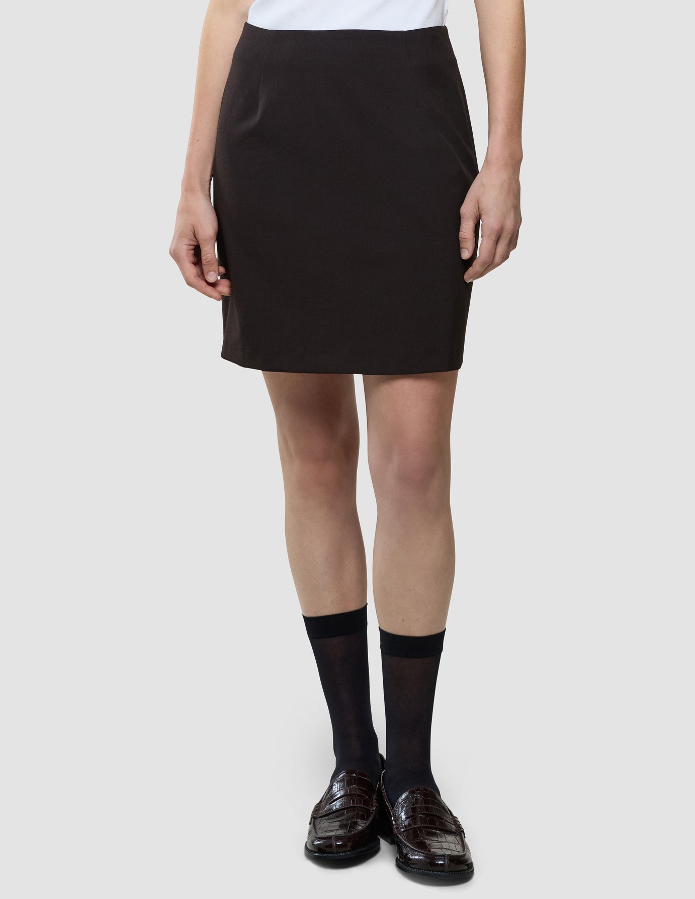 Ease Shirt Skirt i Mocha Melange, helfigur på model med hvid top og sorte sokker.